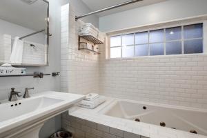 a white bathroom with a tub and a sink at The Waves in Cannon Beach