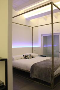 a bedroom with a canopy bed with a purple light at B&B COCO in Calvisano