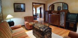 a living room with a couch and a tv at La Casa del Regidor Hotel Rural Fermoselle in Fermoselle