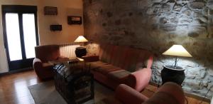un soggiorno con divani e un muro in pietra di La Casa del Regidor a Fermoselle