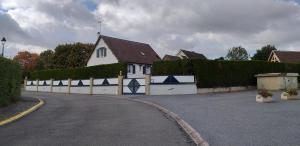a white house with a fence next to a driveway at studio mezzanine 5 personnes in La Roche