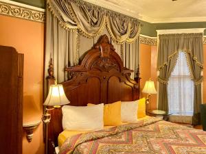 a bedroom with a large wooden bed with yellow pillows at The Gables Inn in Hot Springs