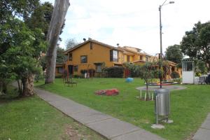 a house with a playground in the yard at Casa Posada Amelia in Bogotá