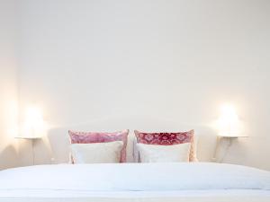 a bedroom with a white bed with four pillows at Family Apartment City Center Baden-Baden in Baden-Baden +39 photos