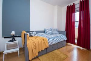 a bedroom with a bed with a yellow blanket on it at Apartman NIVA Daruvar in Daruvar