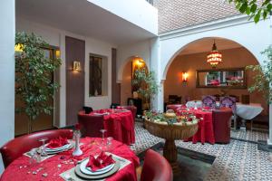 a dining room with red tables and chairs and a room with at Dar Sholmes in Marrakesh