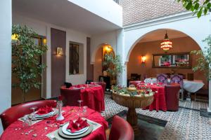 a dining room with red tables and chairs and a room with at Dar Sholmes in Marrakech