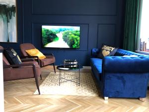 a living room with a blue couch and a tv at Apartamenty Royal Point Bed & Bath in Szczecin