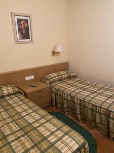 a hotel room with two beds and a table at Mirasierra in Bustarviejo