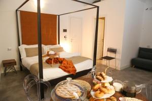 a room with a bed and a table with food at B&B Salerno al Duomo in Salerno