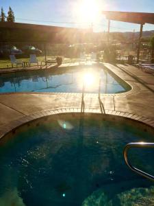 a swimming pool with the sun setting in the background at Mountain View Lodge in Chelan