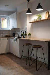 a kitchen with a counter and two stools in it at Studio Krynickie in Krynica Zdrój