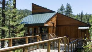 a large wooden cabin with a staircase leading up to it at Charming Studio Condo in Truckee