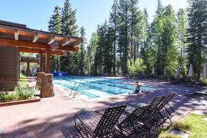 a swimming pool with chairs and a person in the water at Charming Studio Condo in Truckee