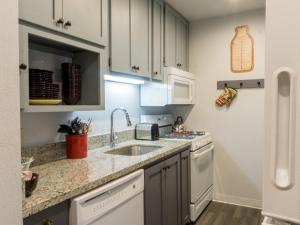 a kitchen with white cabinets and a sink at Charming Studio Condo in Truckee