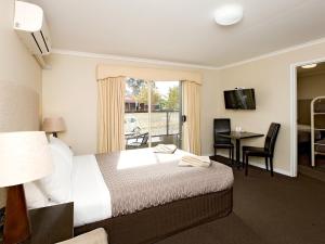 ein Hotelzimmer mit einem Bett und einem Balkon in der Unterkunft Ballarat Central City Motor Inn in Ballarat