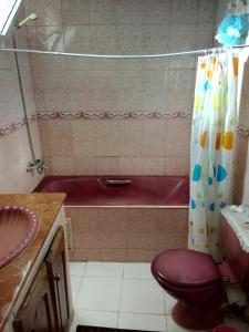 a bathroom with a red toilet and a tub at Naima's House in Rabat