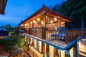 a house with a wrap around deck at night at Breeze Villa in Nusa Lembongan