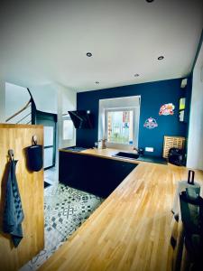 uma cozinha com paredes azuis e uma pista de dança em Gîte « La Vague » 8-10 pers em Grandcamp-Maisy