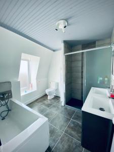 a white bathroom with a sink and a toilet at Gîte « La Vague » 8-10 pers in Grandcamp-Maisy +21 photos