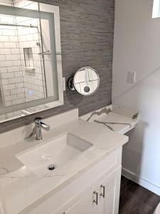 ein weißes Badezimmer mit Waschbecken und Spiegel in der Unterkunft Seaside RV resort in Seabrook
