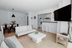 uma sala de estar com um sofá branco e uma mesa em Ushuaia Homes Martial Apartments em Ushuaia