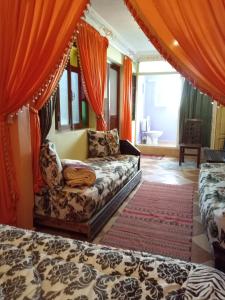 ラバトにあるNaima's Houseのリビングルーム(ソファ、オレンジ色のカーテン付)