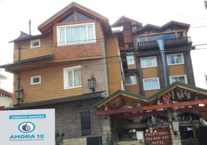 a large wooden building with a sign in front of it at Ruca Cheli Village Ski Hotel in San Carlos de Bariloche