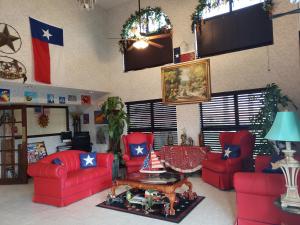 soggiorno con mobili rossi e bandiera americana di Texas Inn Harlingen a Harlingen