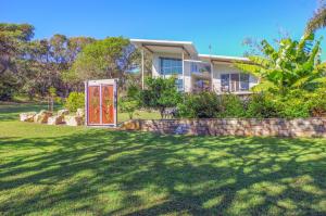 a house with a red door in a yard at Drifted Away in Valla Beach