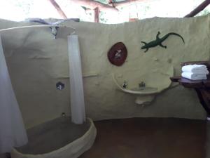 ein Badezimmer mit einer Eidechse an der Wand und einem Waschbecken in der Unterkunft Danta Corcovado Lodge in Rincón