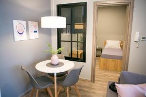 een kleine tafel en stoelen in een kamer met een slaapkamer bij STS EIGHT 7 New Luxury Apartment in Thessaloniki