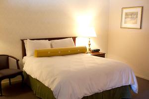 a bedroom with a bed with a yellow pillow on it at Coral Reef Inn & Condo Suites in Alameda