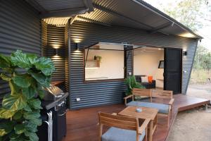 a backyard patio with a table and chairs at Hideaway Litchfield in Rakula