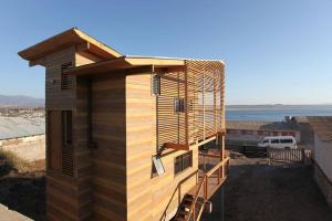 a wooden house with a staircase on the side of it at Tongoy Beach Tinyhouse in Tongoy