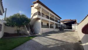 a large white building with a parking lot at kitnet da izumi in Cabo Frio