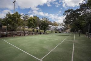 a tennis court with a net on it at McMillans of Metung Coastal Resort in Metung