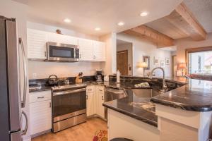 a kitchen with white cabinets and stainless steel appliances at Rustic-Contemporary 3Br With Great Views Condo in Crested Butte +21 photos