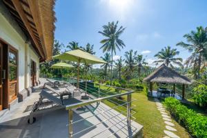 an outdoor patio with tables and chairs and umbrellas at Villa Themma Jungle - Sumptuous 3BR Luxury Villa with Majestic Jungle View North of Ubud in Ubud