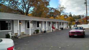 a red car parked in front of a building at Mother Lode Lodge in Mariposa