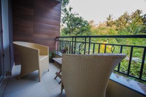 balcón con 2 sillas y vistas a los árboles en Mariners Bay Resort en Mandrem