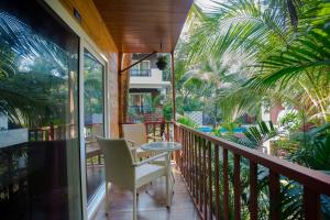 a balcony with a table and chairs and palm trees at Mariners Bay Resort in Mandrem