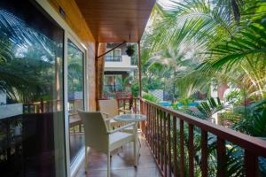 balcón con mesa, sillas y palmeras en Mariners Bay Resort en Mandrem