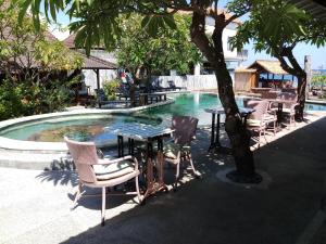 uma mesa e cadeiras ao lado de uma piscina em Classic Beach Villas em Amed