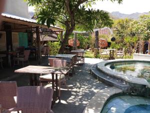 a patio with tables and chairs next to a pool at Classic Beach Villas in Amed