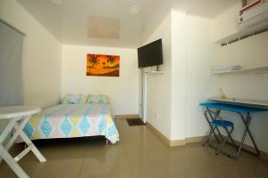 1 dormitorio con cama, mesa y escritorio en Posada Dima Cresida, en San Andrés