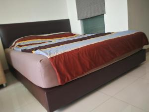 a large bed with a black frame in a bedroom at The Riviera Wongamat Hong Apartment in Pattaya North