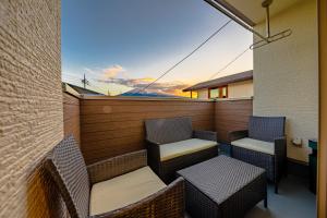 a balcony with chairs and tables and a sunset at enjoy Mt.Fuji B in Fujiyoshida