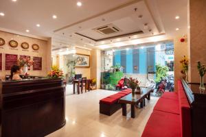 a restaurant with a bar and a woman sitting at a counter at Azura Hotel in Nha Trang