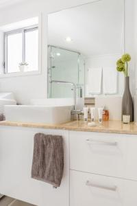 a white bathroom with a sink and a mirror at Immaculate Apartment close to Brisbane City and Airport in Brisbane